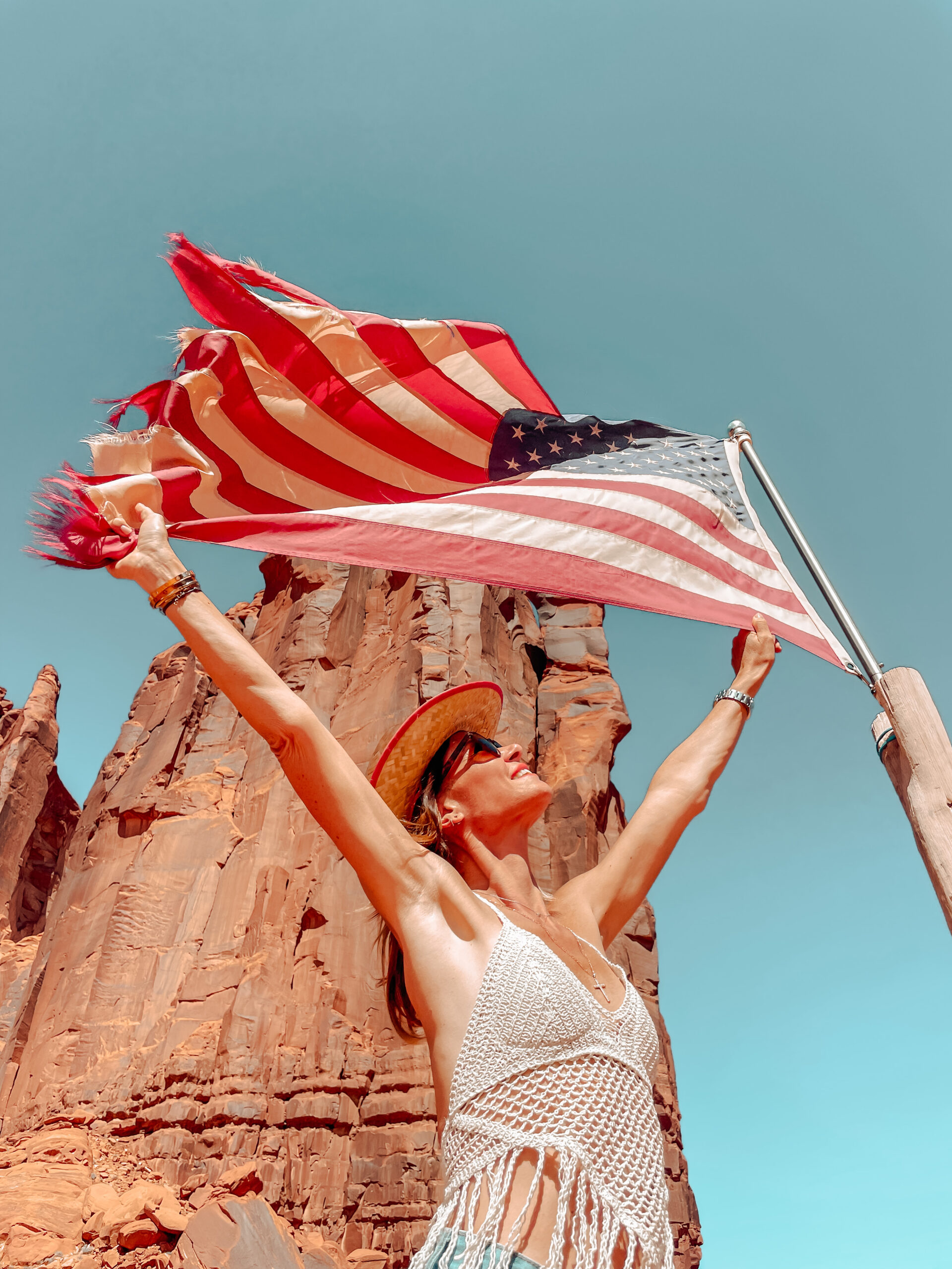 Sabrina brandissant un drapeau américain dans le désert, symbole de sa LLC américaine d'entrepreneuse expatriée