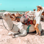 Sabrina à dos de chameau sur la plage d'Essaouira au Maroc, symbole de sa vie d'expatriée et de son business en ligne depuis l'étranger