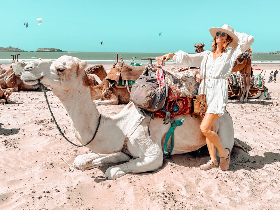 Sabrina à dos de chameau sur la plage d'Essaouira au Maroc, symbole de sa vie d'expatriée et de son business en ligne depuis l'étranger